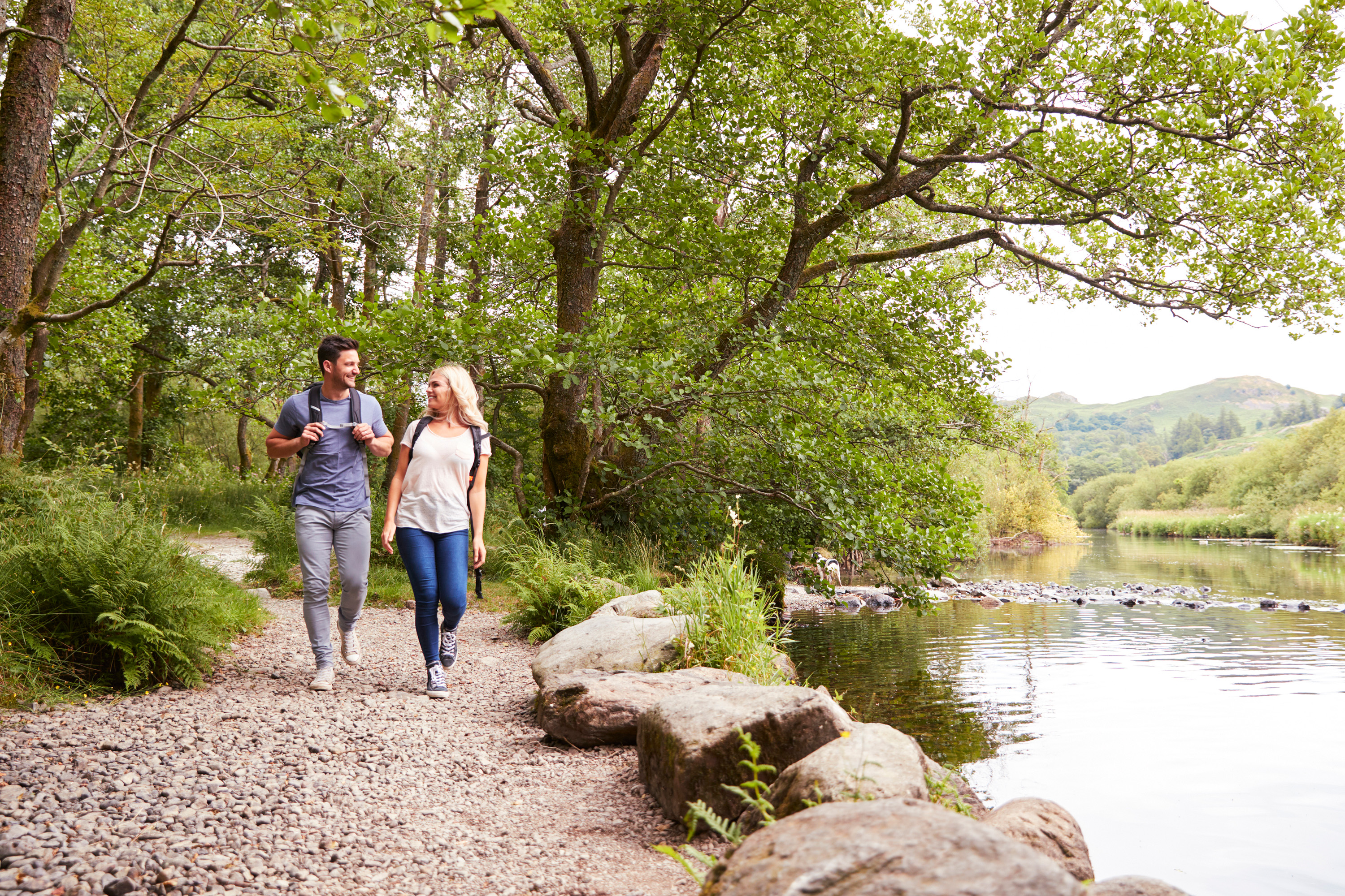 couple hiking by a river bank