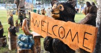 Bear carving holding welcome sign